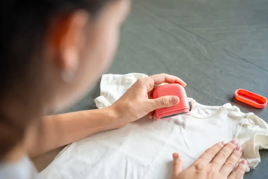 Close up view of woman with a stamp with a name for signing children's things. Identification of personal clothing.