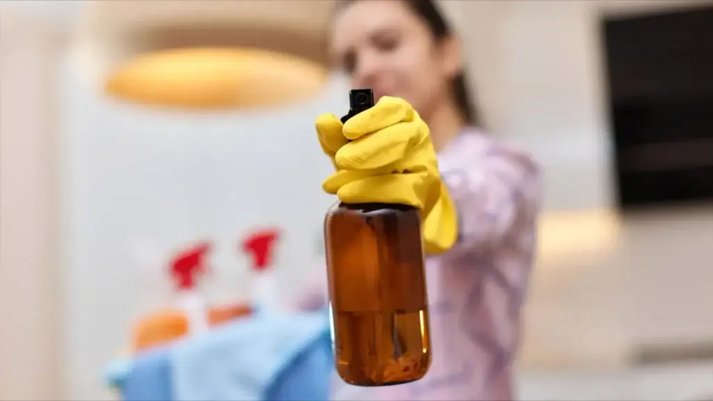 cleaner holding spray bottle yellow gloves