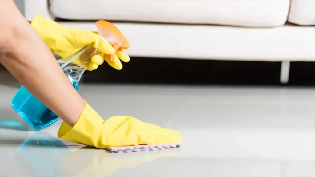 hands scrubbing floor with spray and cloth