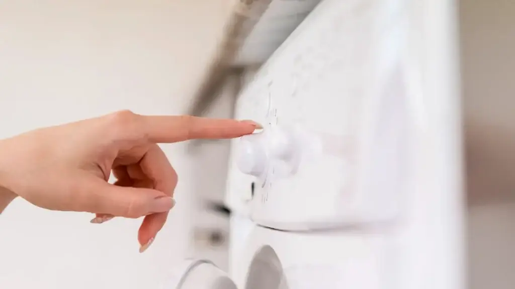 hand adjusting washing machine dial