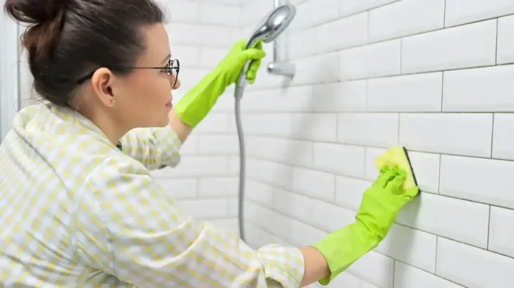 woman cleaning shower tiles