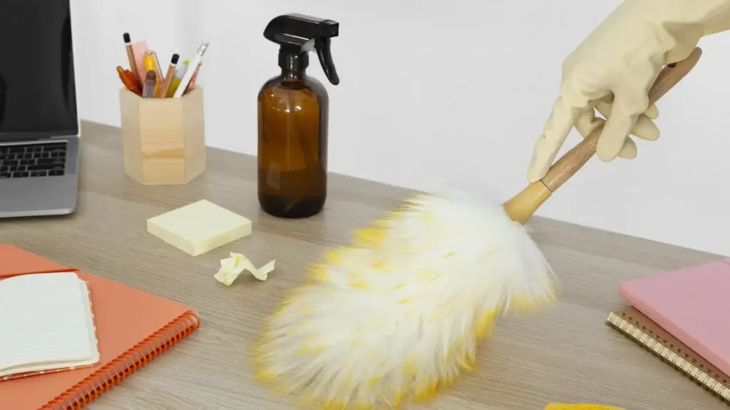 Office desk cleaning with duster and spray bottle
